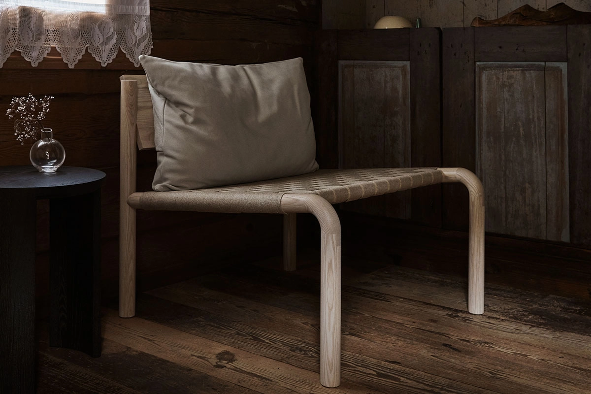 Kaski lounge chair by Joanna Laajisto showing ash wood frame with linen seat and leather cushion