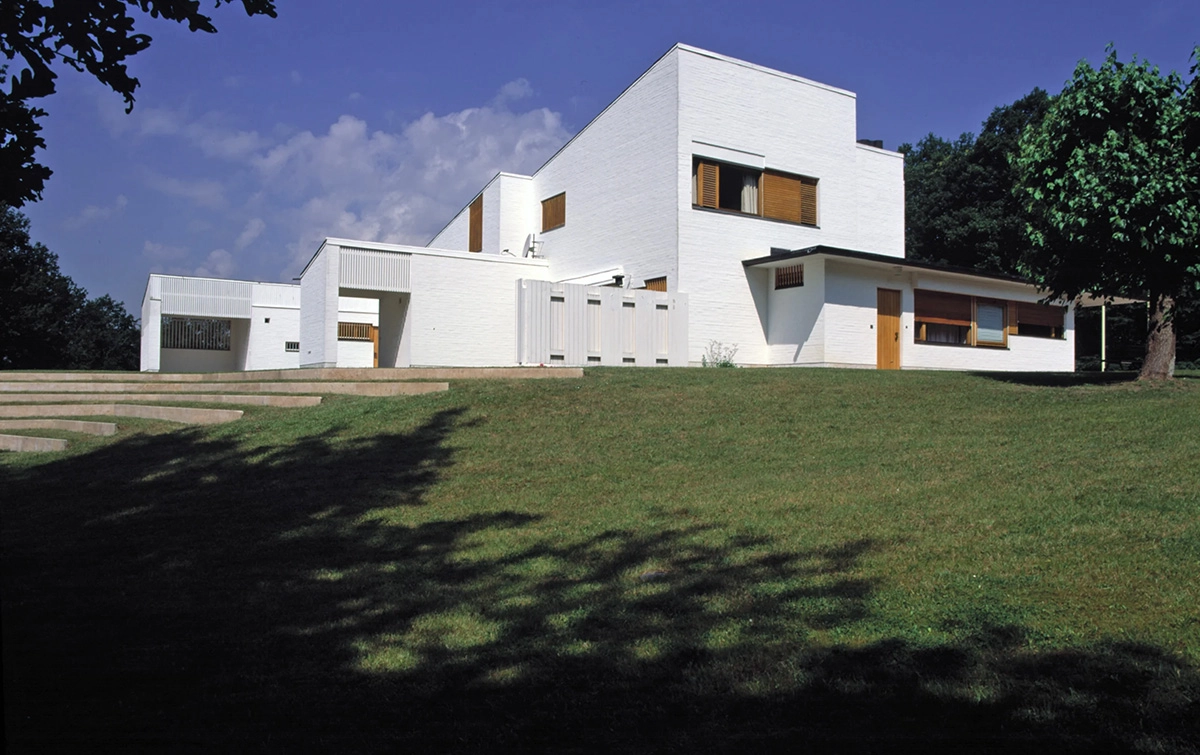 Exterior view of Maison Louis Carré showing Alvar Aalto's distinctive architecture with sloping roof and natural materials