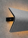 Close-up of Khodi Feiz's Vika acoustic wall light showing the elegant curve and soft illumination effect.