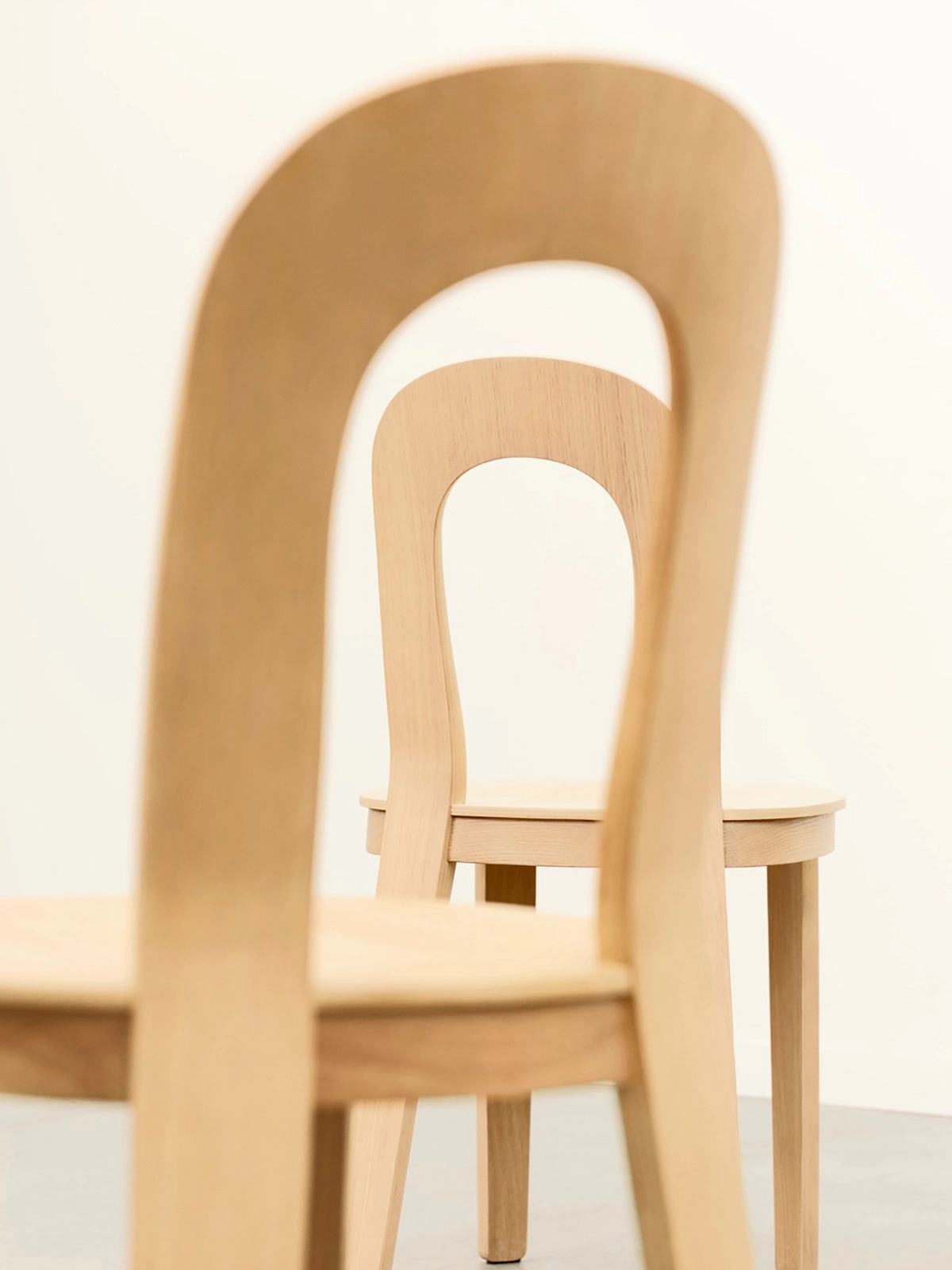 Close-up of Olivia Chair's form-pressed oak construction and ergonomic backrest opening design