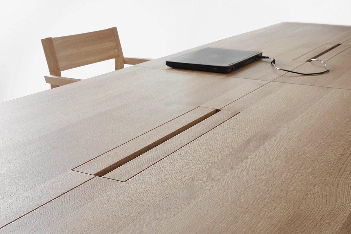 Close-up of LINEA KVP11 table's storage solution for digital technology, evidence of Nikari's innovative design