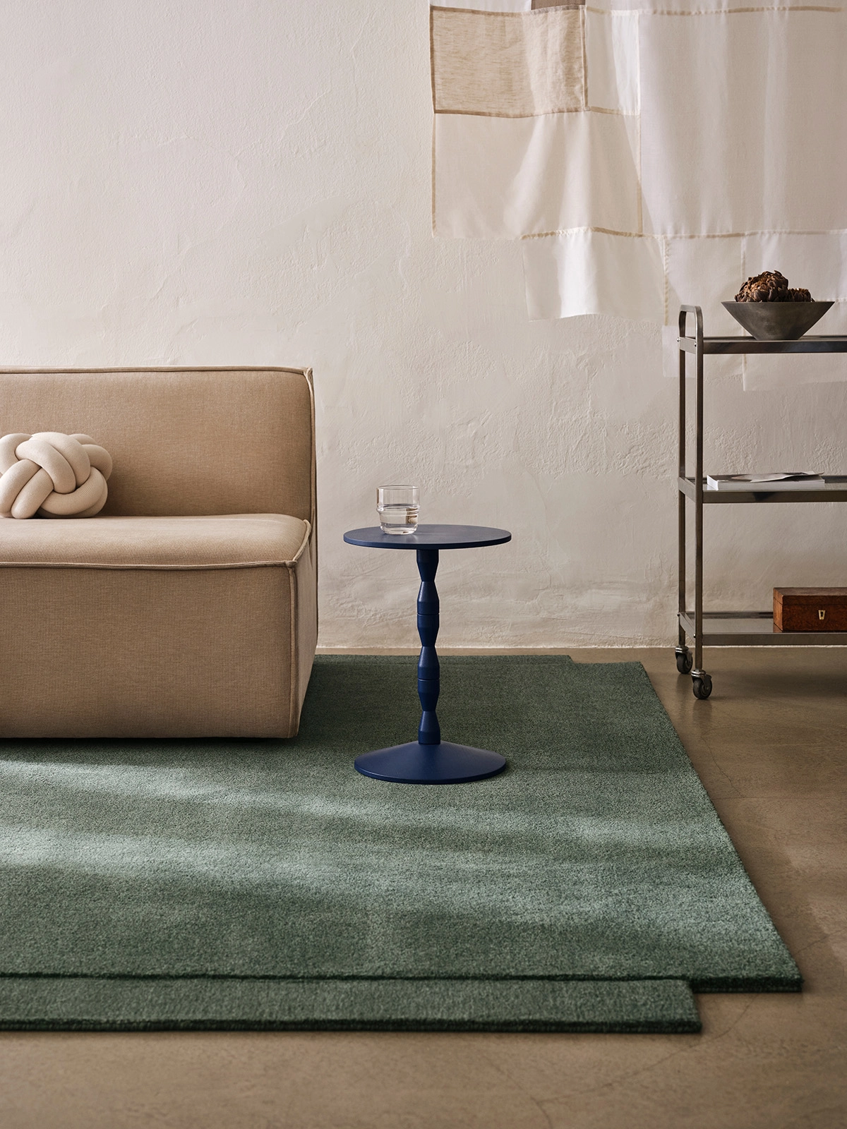 Level Rug in green colorway anchoring a minimalist living space with furniture arranged to highlight its dimensional qualities.