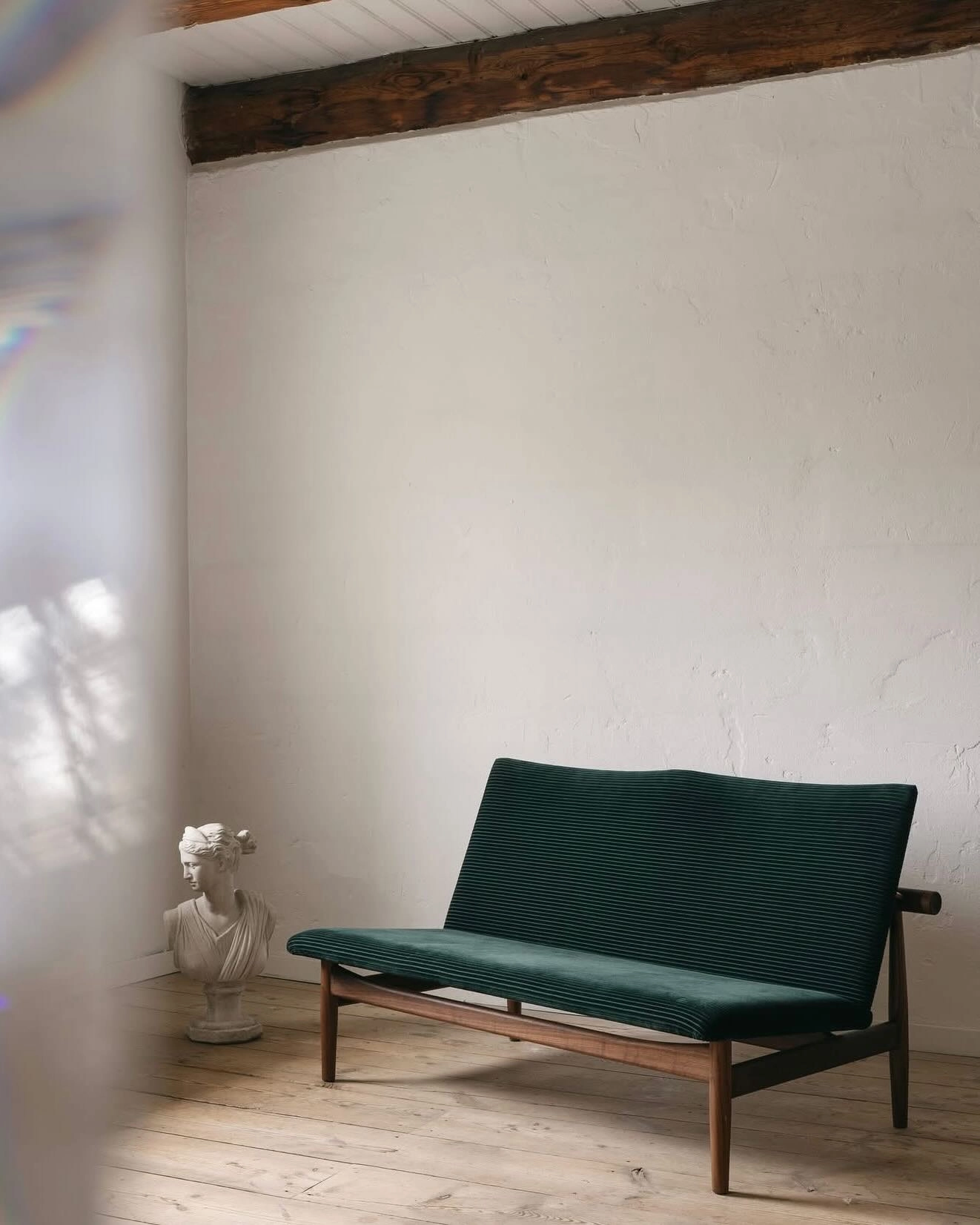 Japan Sofa in walnut finish with textile upholstery displayed against neutral backdrop highlighting its architectural proportions.