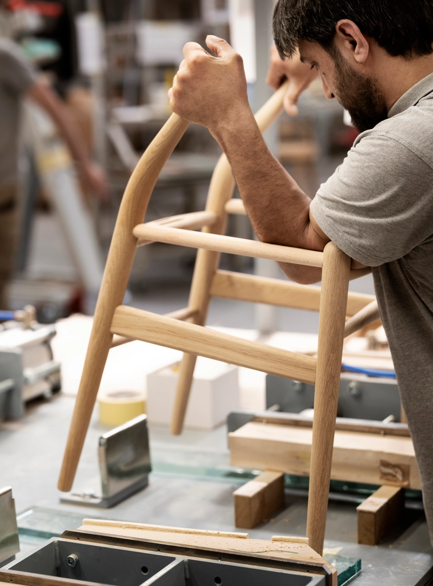 Carl Hansen & Søn craftsman hand-finishing an authentic Wishbone Chair in the company's Danish workshop