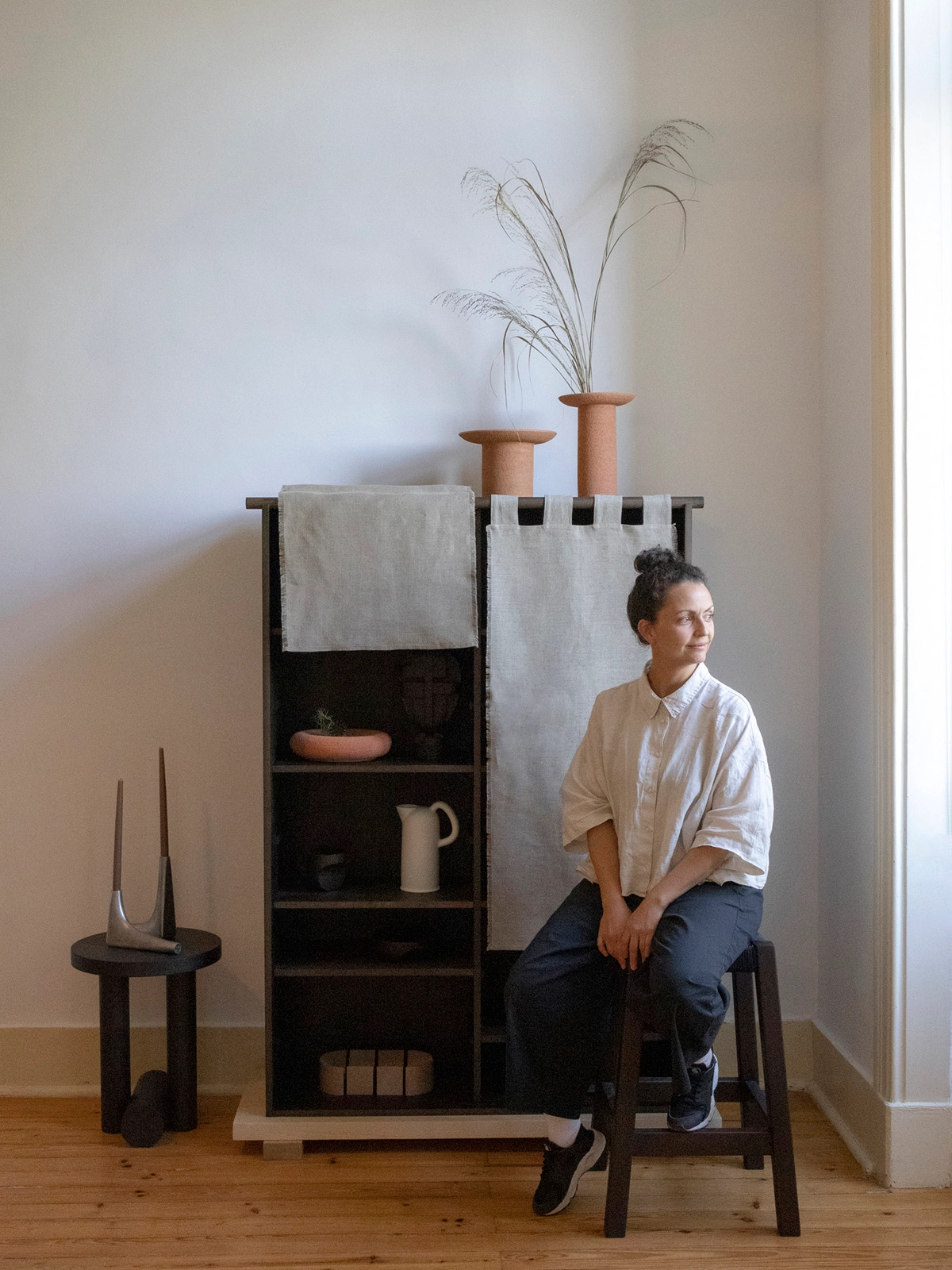 Designer Silje Nesdal examining the linen detail of her Veil Cabinet creation for Origin Made.