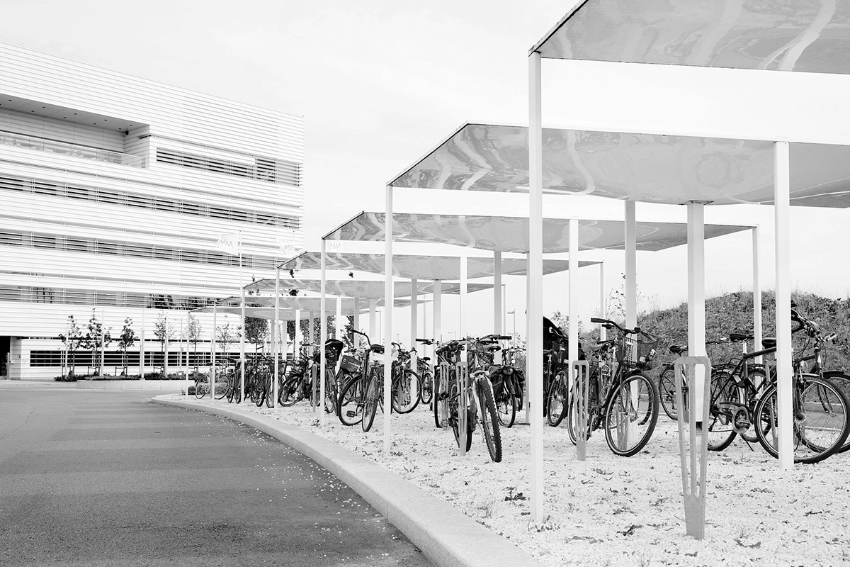 Close-up detail of Våg bike shelter's fiberglass construction showing the seamless wave pattern