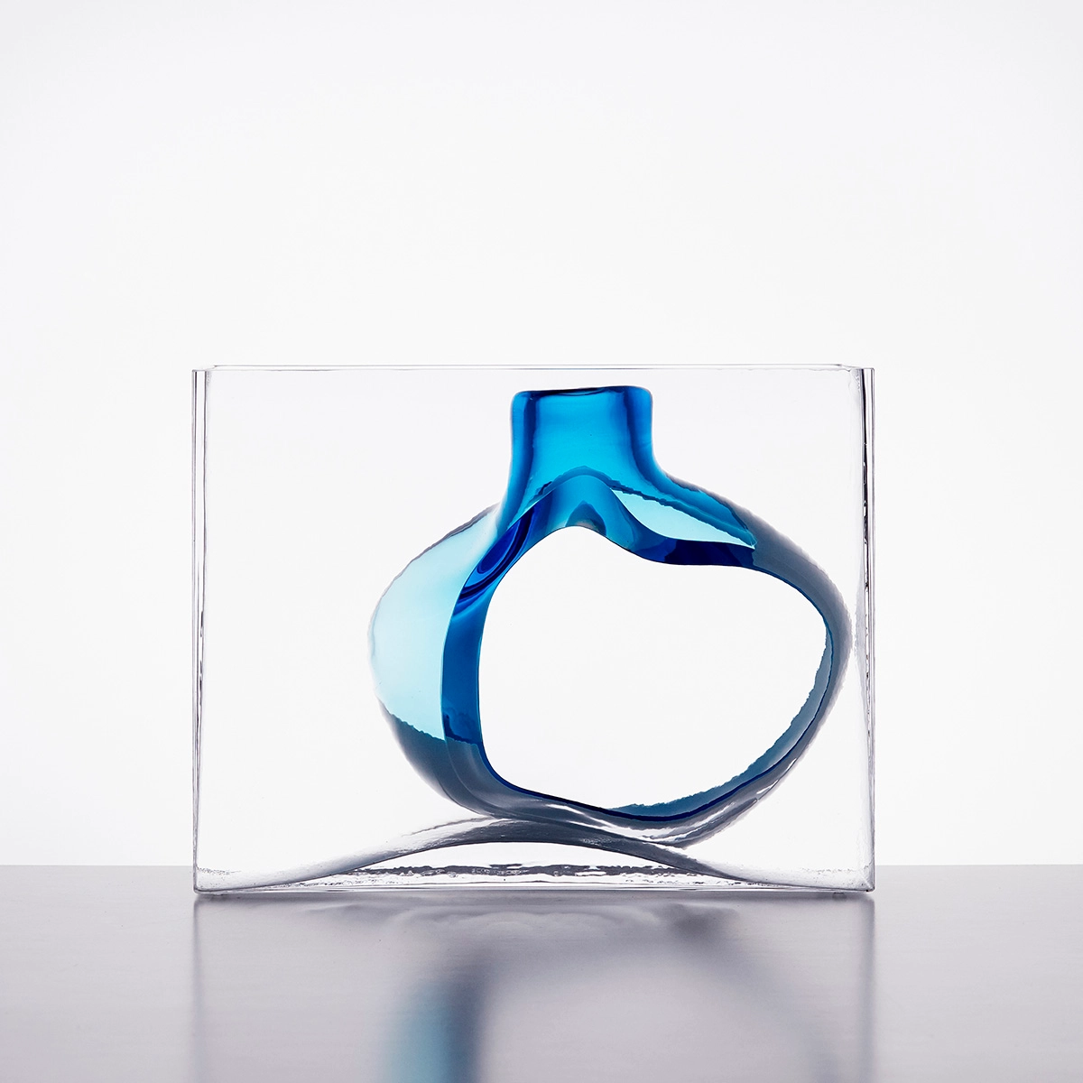 Gallery visitor viewing Matti Klenell glass sculptures in natural light at Galleri Glas contemporary exhibition